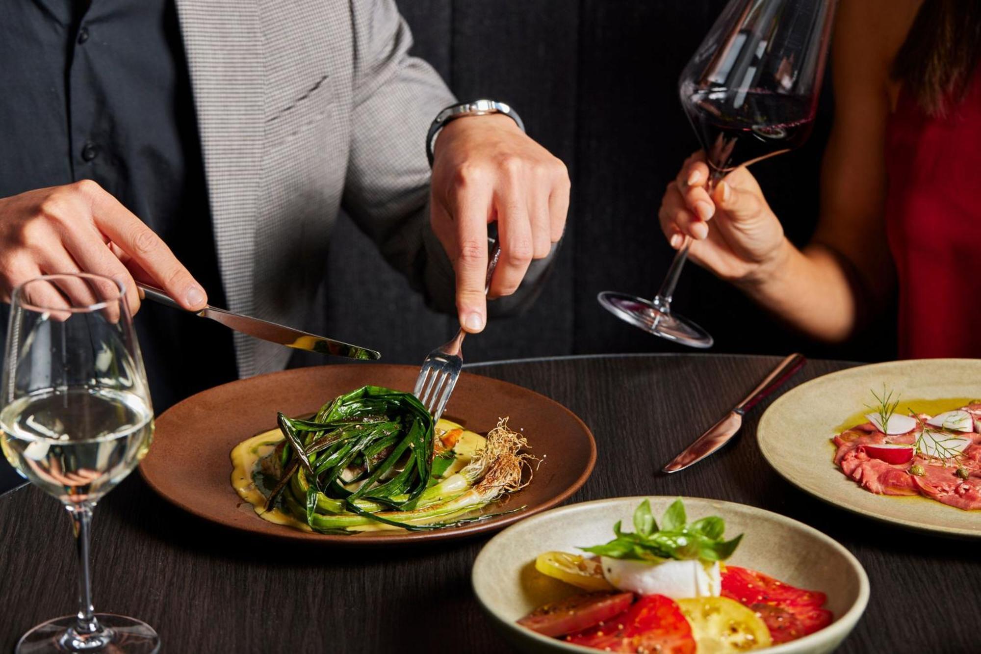 Melbourne Marriott Hotel Docklands Luaran gambar A man using a knife and fork to cut into a meal